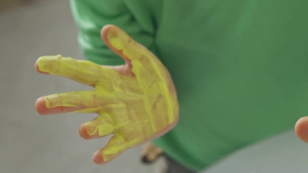 Pintura con pintura amarilla y azul en manos de niños — Vídeos de Stock