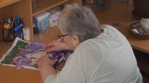 一个年长的妇女刺绣，选择线的颜色 — 图库视频影像