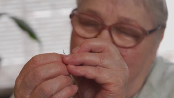 Close-up de mulher idosa enfiando uma agulha — Vídeo de Stock