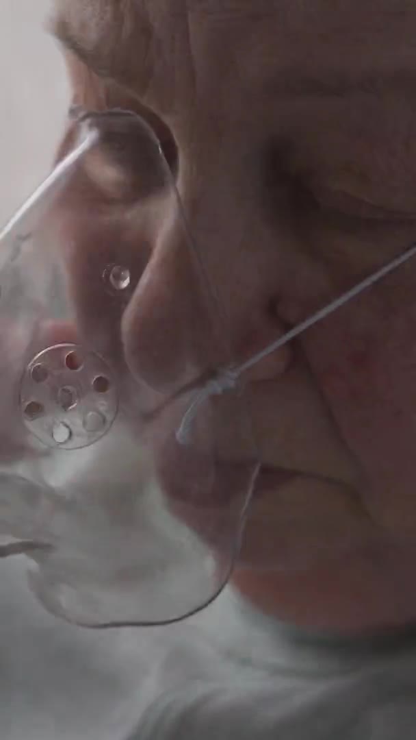 Donna anziana indossava e respirava con una maschera di ossigeno. Formato verticale — Video Stock