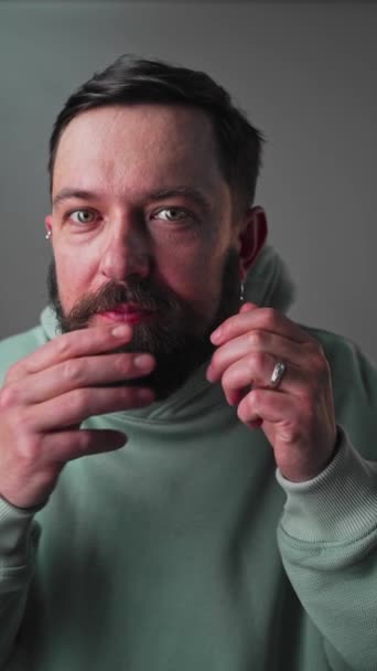 Verticaal formaat Close-up van knappe man die baard en snorren controleert — Stockvideo