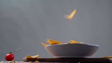 Tortilla cipsleri beyaz kaseye düşüyor.