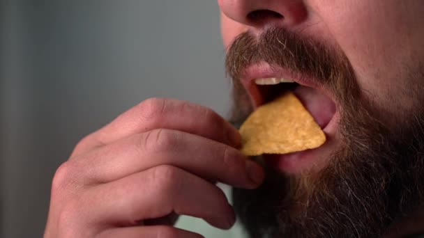 Чоловік їсть чіпси в повільному русі. Крупним планом — стокове відео