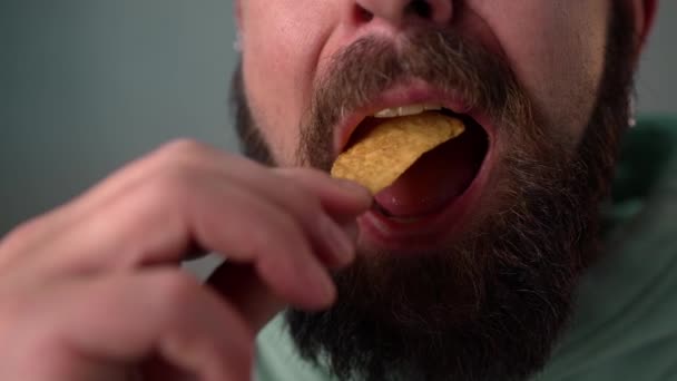 Чоловік їсть чіпси в повільному русі. Крупним планом — стокове відео