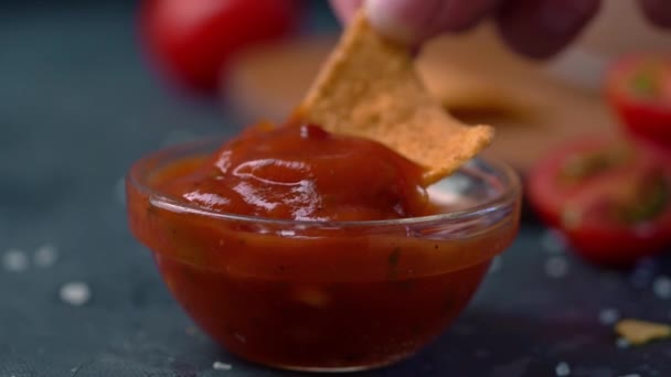 Hand dipping Tortillas chips in salsa sauce — Stock Video