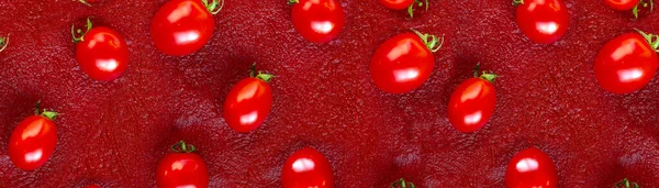 Modello di pomodoro ciliegia su uno sfondo di concentrato di pomodoro rosso o ketchup. Posa piatta, vista dall'alto — Foto Stock