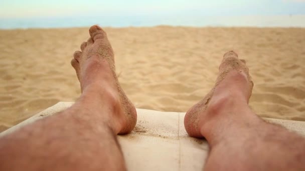 ポフ男の足はビーチに横たわっている — ストック動画