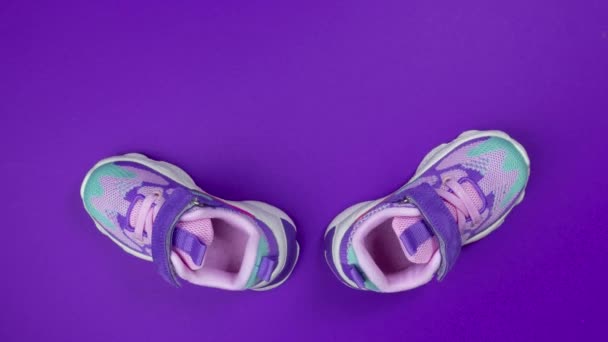 Multicolored Girls sneakers with mershmello on purple background stop motion — Stock Video