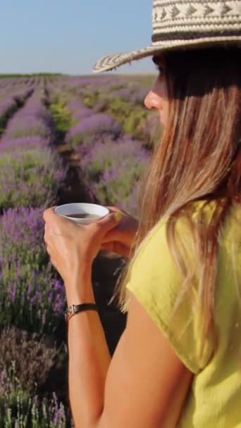 Woman with a cup of tea in her hand enjoys the view of the lavander field. Vertical video — Stock Video