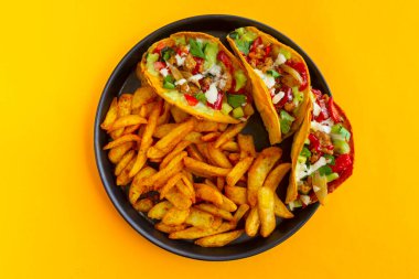 Sarı arka planda Fransız patatesli Meksika tacosu.