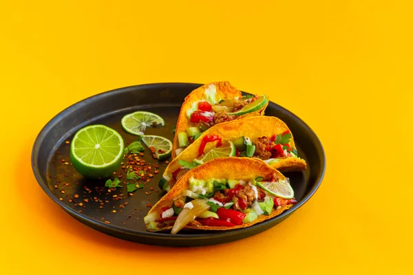 Mexikanischer Taco in schwarzer Pastete auf gelbem Hintergrund — Stockfoto