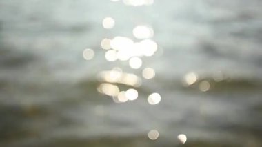 Bulanık güneşin yumuşak odağı denizin su yüzeyindeki noktalar..