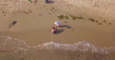 İki küçük kızın kumsaldaki kumsalda oynadığı bir video.