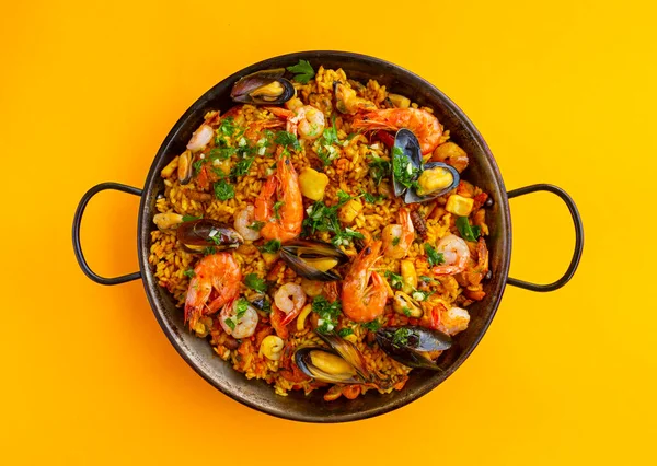 Arka plandaki tavada geleneksel İspanyol deniz ürünleri paella 'sı