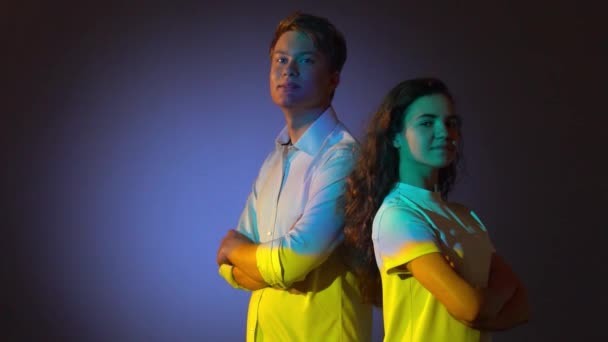 Dois adolescentes posando em estúdio com projetor Reflexão da bandeira ucraniana azul e amarela — Vídeo de Stock