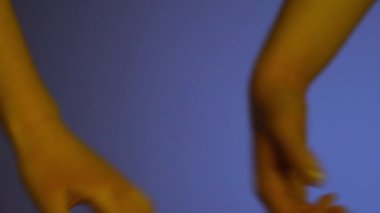 Mavi arka planda el ele tutuşan çift.