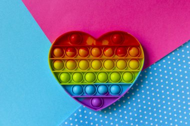 Renkli duyusal oyuncak kıpırdaması çok renkli arka plana kalbi yerleştir