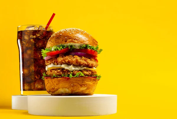 Sarı arka planda kola ile nefis bir hamburger.