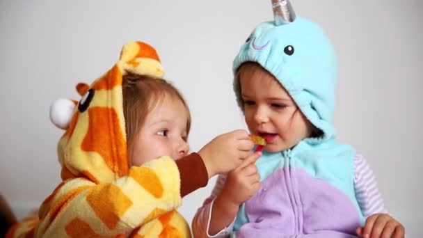 Two sisters with candies in halloween costumes — Stock Video