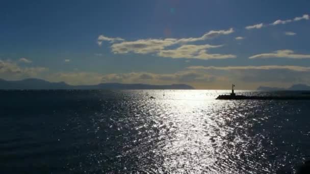 Sparkling water surface ,horizon,skyline, silhouettes breakwater and motor boat — Stock Video