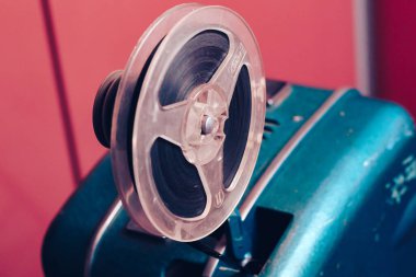 Pembe desenli arka planda eski bir 8 mm film projektörü. Retro stili 60 'ın pankart konsepti