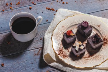 Çikolatalı pasta tatlısı ve kırsal masada bir fincan kahve.