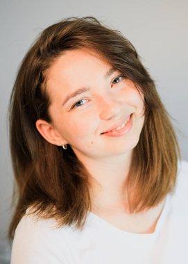 Gülümseyen ve kameraya bakan birinin yakın çekimi.