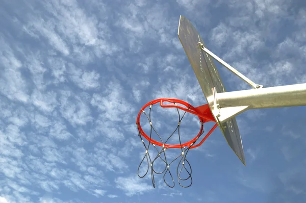 Aro de baloncesto rojo contra un cielo azul en un parque callejero . — Foto de Stock