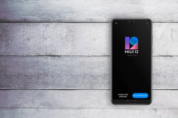 Üzerinde MIUI12 Android tabanlı işletim sistemi logosu olan akıllı telefon ekranı. Düzenleyicinin metni için boş kopyalama alanı.