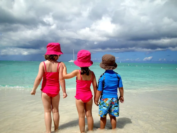 Dulces niños en la playa tropical de pie mirando al océano —  Fotos de Stock