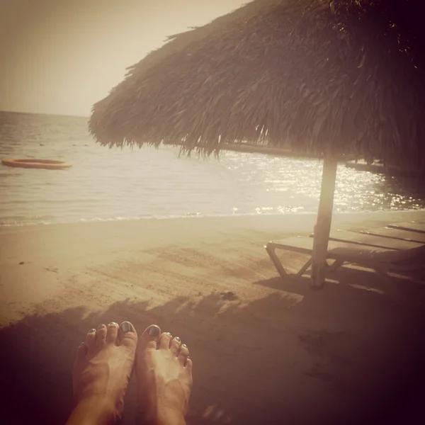 Instagram image of womans feet relaxing on tropical beach — Stock Photo, Image