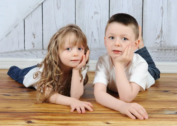 Young brother and sister laying together in floor — Stock Photo, Image