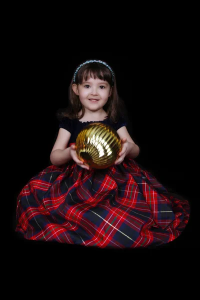 Young girl sitting with large christmas bulb isolated — Stock Photo, Image