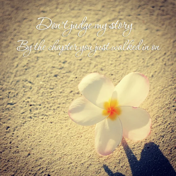 Красива тропічна квітка в піску з цитатою — стокове фото