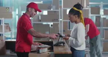 Postane. Örgü örgülü Afro-Amerikalı Güzel Kadın Postane Müdürüyle Konuşuyor Karton Paket Kutusu Alınıyor.