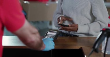 Akıllı telefon teknolojisi kullanan genç Afrikalı sıradan bir kadın modern postanede paket teslimatı için ödeme yapılmıyor..