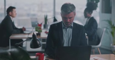 Girişimci iş adamı resmi takım elbiseli yetişkin beyaz adam şirket ofisindeki dizüstü bilgisayarla dijital proje finans raporu hazırlıyor..