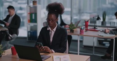 Cep Telefonu Sosyal Ağı Kullanan Afrikalı Amerikalı Genç Kadın Kurumsal Kadın Çağdaş Ofiste Dijital Aygıt Dizüstü Bilgisayarı Uyguladı. Modern İnsanlar Yaşam Tarzı.