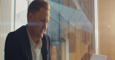 Bir kafede dizüstü bilgisayar kullanan bir iş adamı. Mutlu hissettiriyor. RED Epic Camera 'da Çekim.