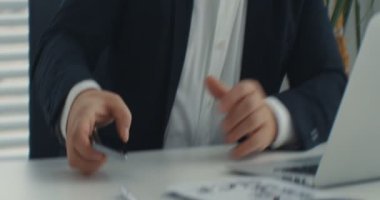 İş adamı telefona bakan ve şok geçiren bir dizüstü bilgisayar kullanıyor. Üzücü bir duygu. Ofiste. RED Epic Camera 'da Çekim.