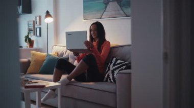 Genç ve güzel bir mulatta kızı dizüstü bilgisayarda çalışıyor telefonu alıyor ve gidiyor. - Evde. Mutlu hissettiriyor. Çağdaş tasarım. RED Epic Camera 'da Çekim.