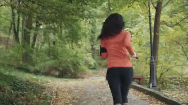 Parkta koşan genç mulatta kadın. Arkadan çerçevele. RED Epic Camera 'da Çekim.