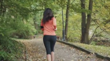 Parkta koşan genç mulatta kadın. Arkadan çerçevele. RED Epic Camera 'da Çekim.