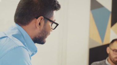 İş dünyası takım liderinin yakın plan çekimleri, yeni projeler. Ofiste dizüstü bilgisayar kullanıyor. RED Epic Camera 'da Çekim.