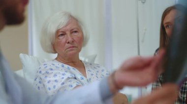 Ne yazık ki yaşlı kadın, doktor raporlarını dinlerken akciğer taramasına bakıp şok geçiriyor. Teşhis olumsuz. Tıbbi randevu. Hastane odası. Hastalar.