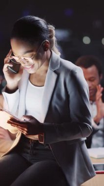 Pürüzsüz bir ortamda telefon ve tablet kullanan profesyonel bir kadın yeteneklerini sergiliyor.