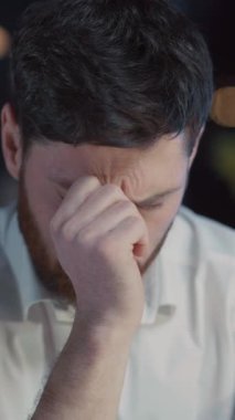 Gıcır gıcır beyaz bir gömlek giyen bir adam derin bir tefekkür duygusu sergiler, gerçek bir iç gözlem somutlaştırır.