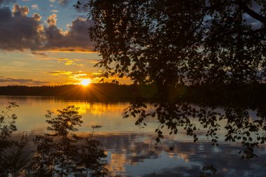 Finlandiya gölü üzerinde güzel bir gün batımı manzarası. Alanı altınla doldurmuşlar.