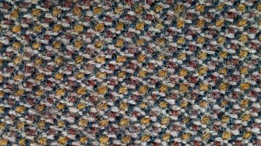 Arka plan olarak kullanılacak kumaş dokusunun makro fotoğrafı. Kumaş turuncu, kahverengi, siyah ve beyaz ipliklerin karışımından yapılmıştır. Sentetik ve yün karışımı. Soyut desen.