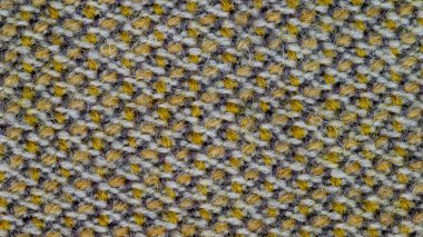 Arka plan olarak kullanılacak kumaş dokusunun makro fotoğrafı. Kumaş sarı, beyaz ve siyah ipliklerin karışımından yapılmıştır. Sentetik ve yün karışımı. Soyut desen.